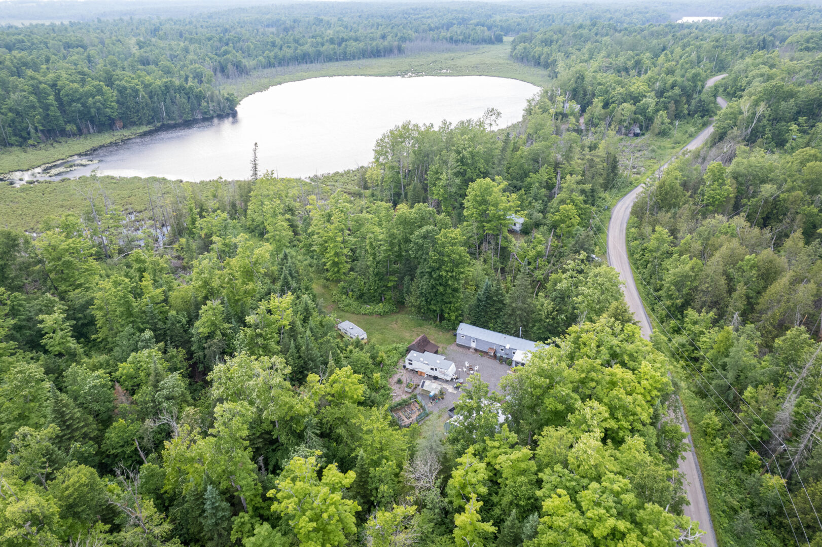 Overview of a cottage in a forested area near a lake