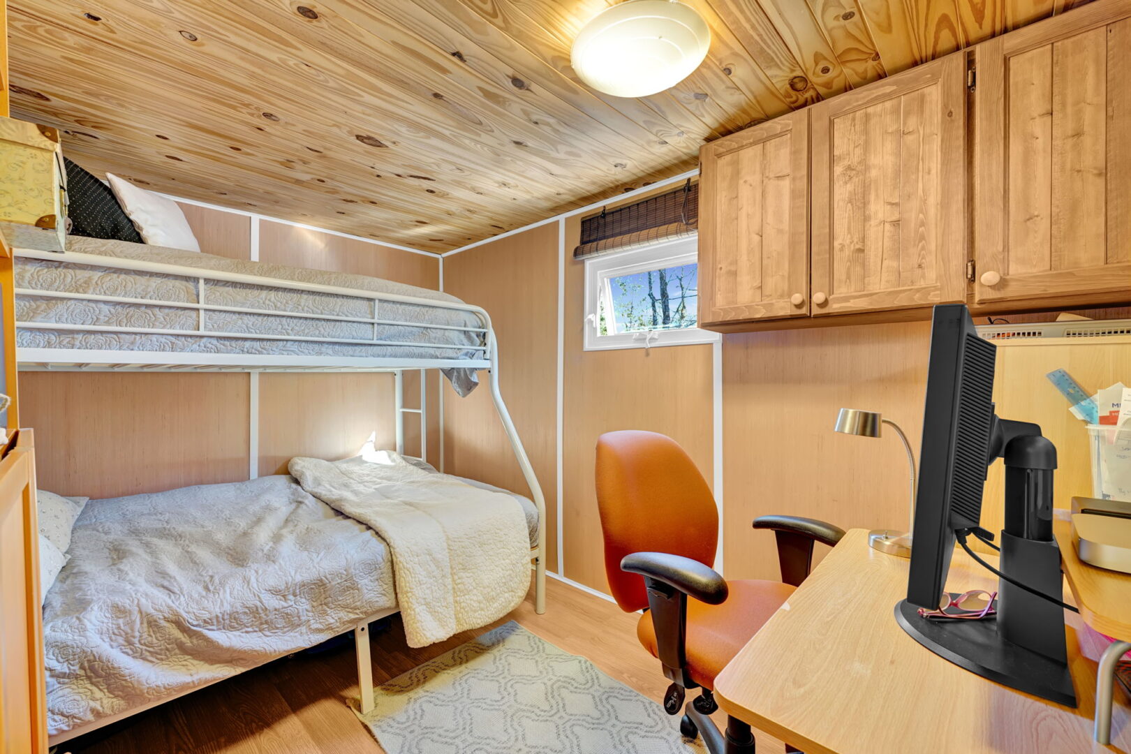 White wire bunk beds in a wood-paneled room