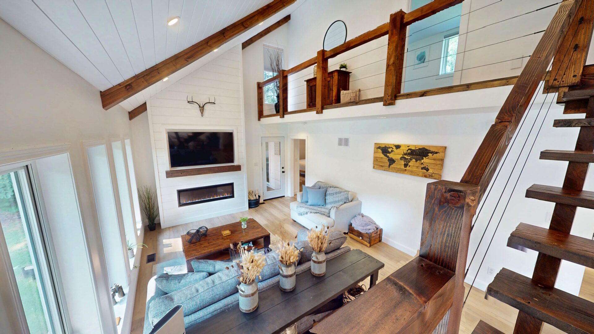 A white living room with a fireplace and couches