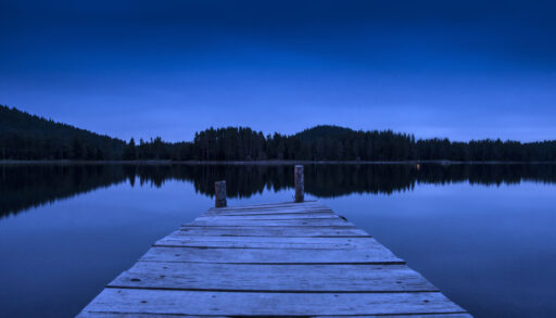 A night shot of a dock on a lake