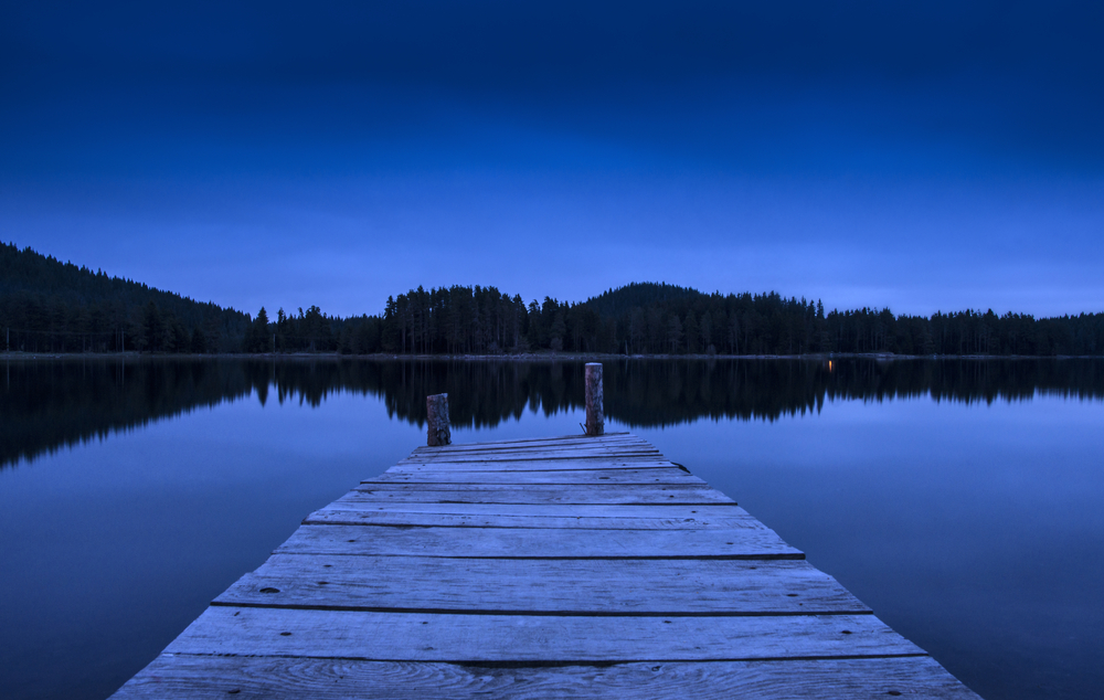 A night shot of a dock on a lake