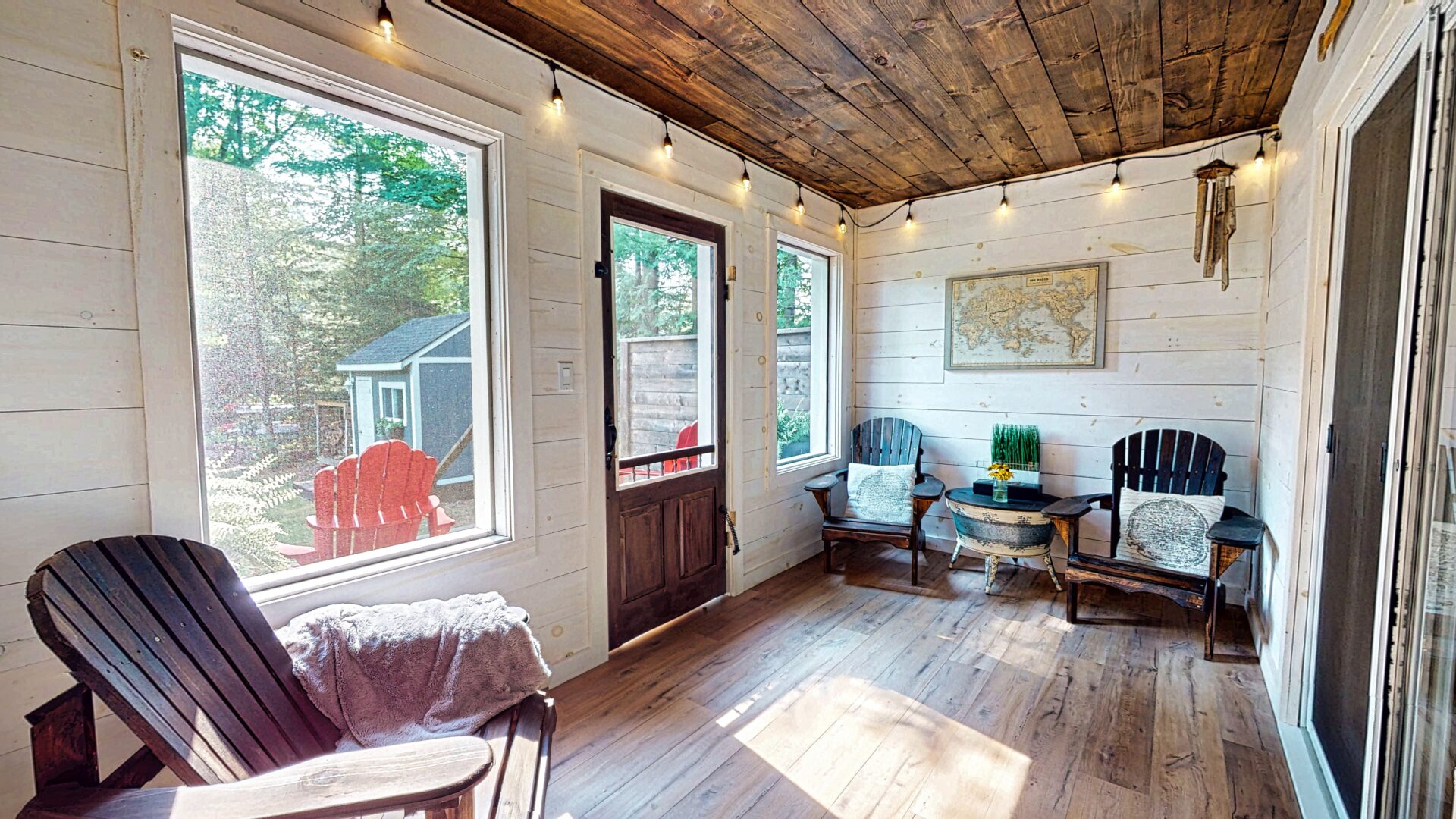 A white sunroom with a wood ceiling