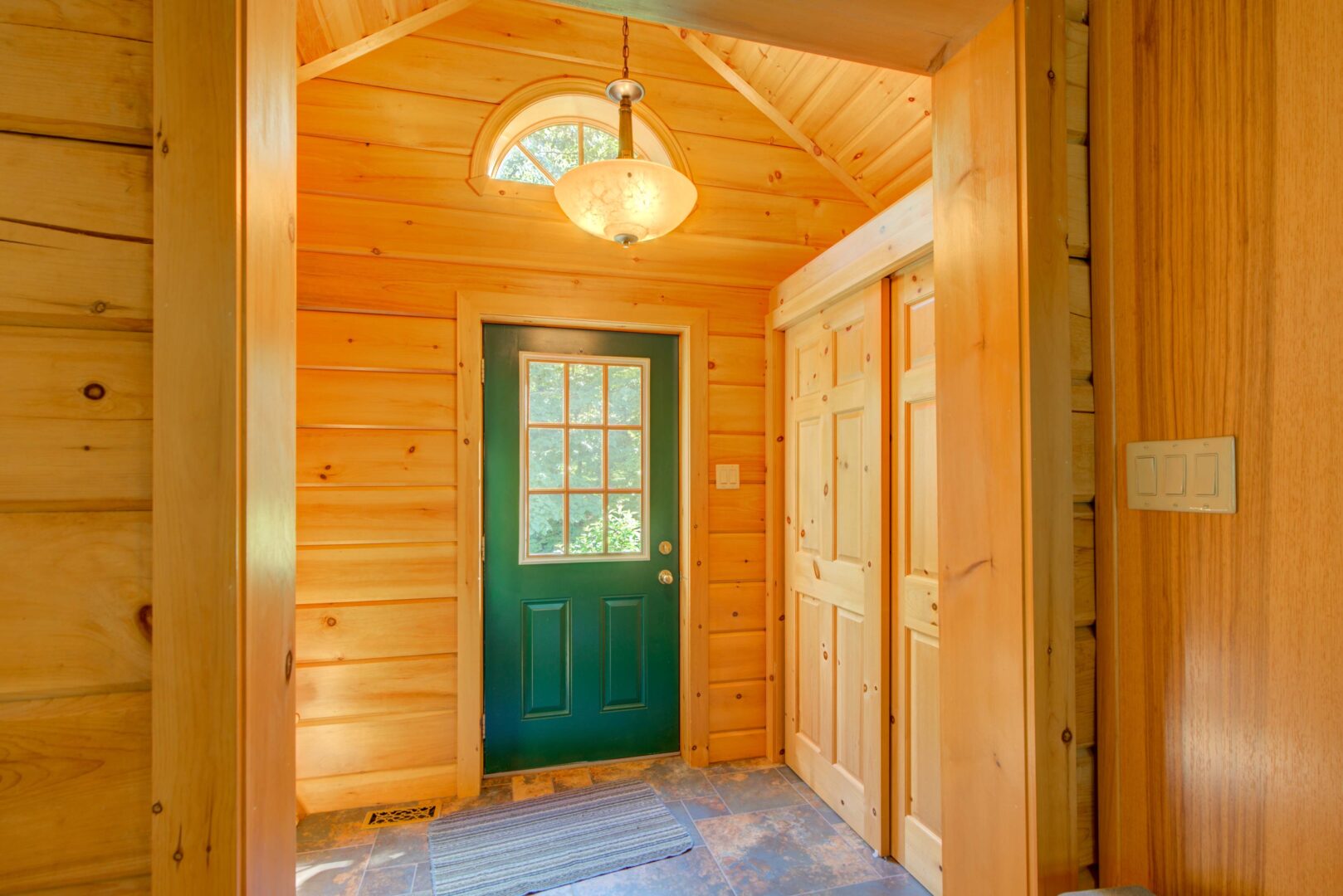 A wood-paneled entryway with a green door