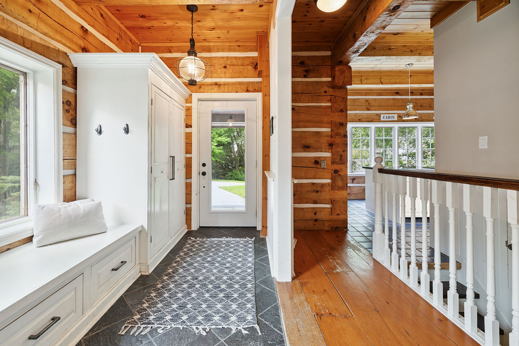 A wood paneled hallway with a white built-in bench