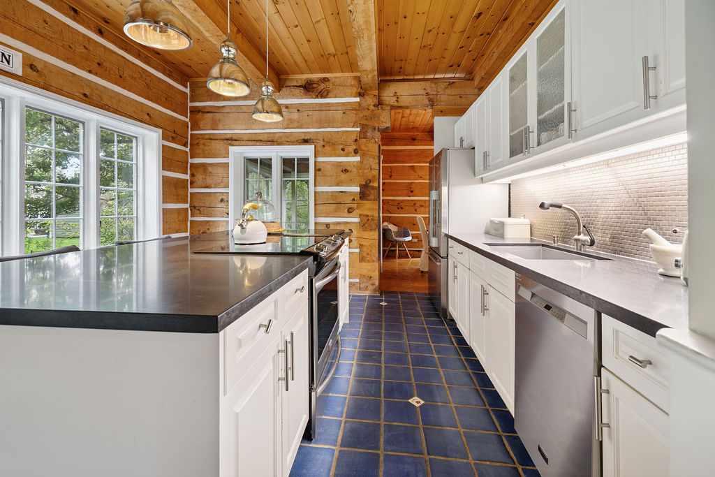 A black and white kitchen island faces white cabinets