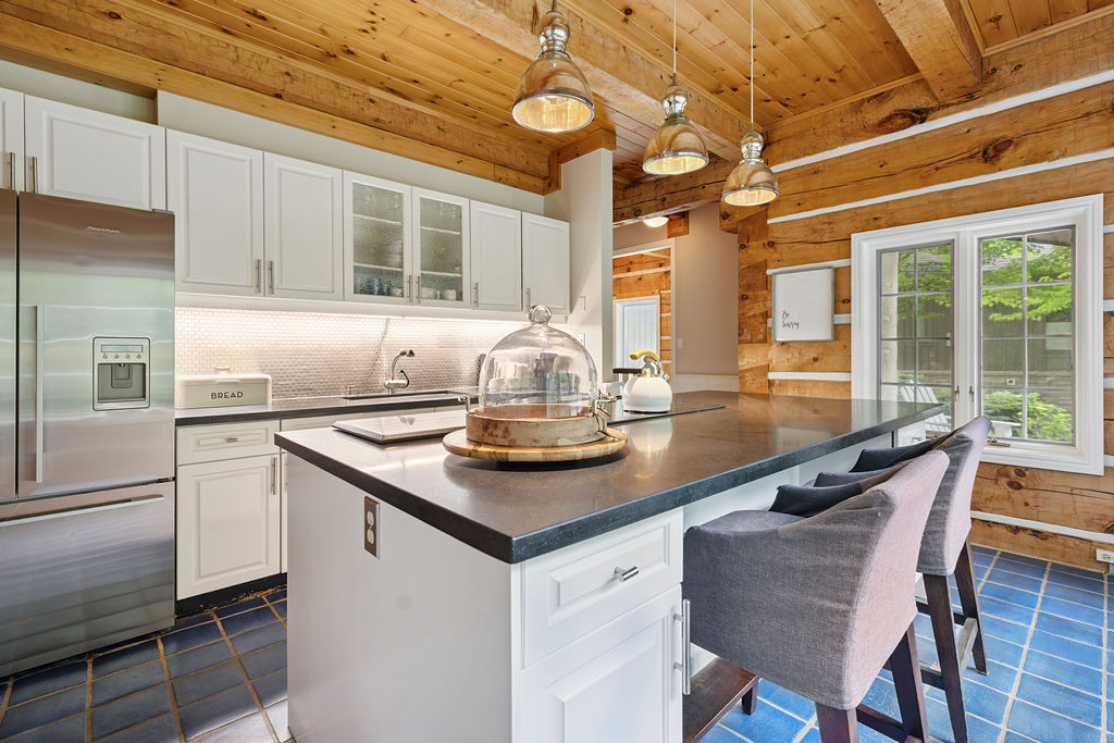 A white kitchen island with black countertops