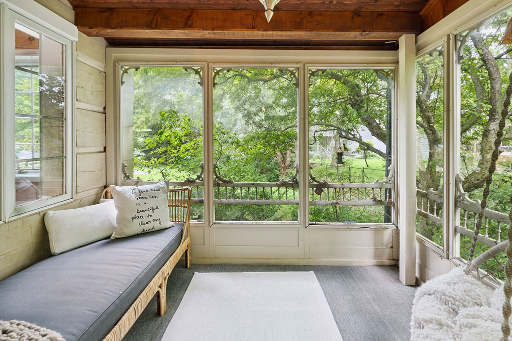 A spacious sunroom with white trim and a grey couch