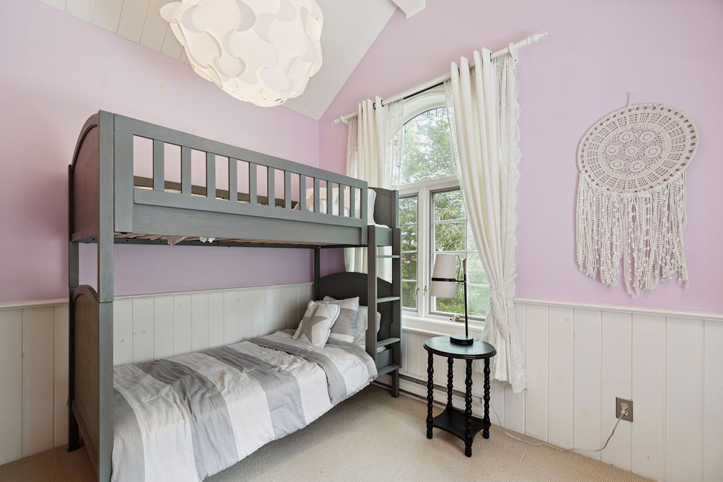 A light pink bedroom with grey bunk beds