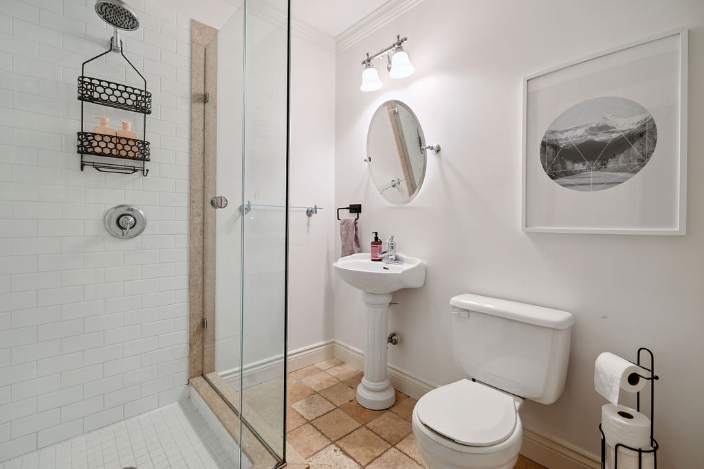 A white bathroom with a glass walk-in shower