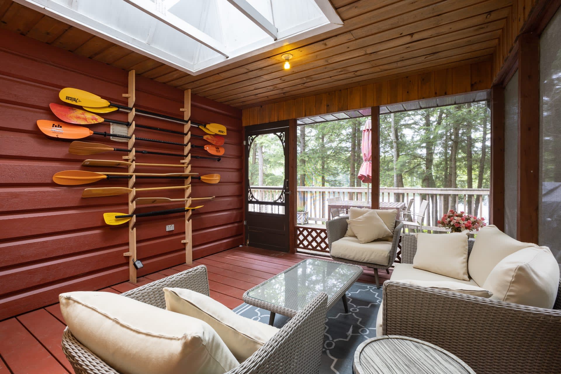 A wood paneled Muskoka room with bright windows