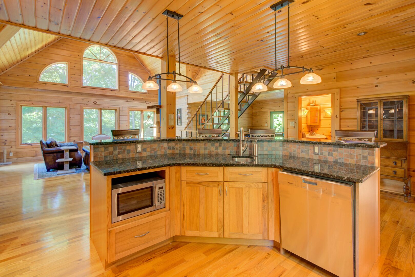 A wood paneled kitchen with dark countertops