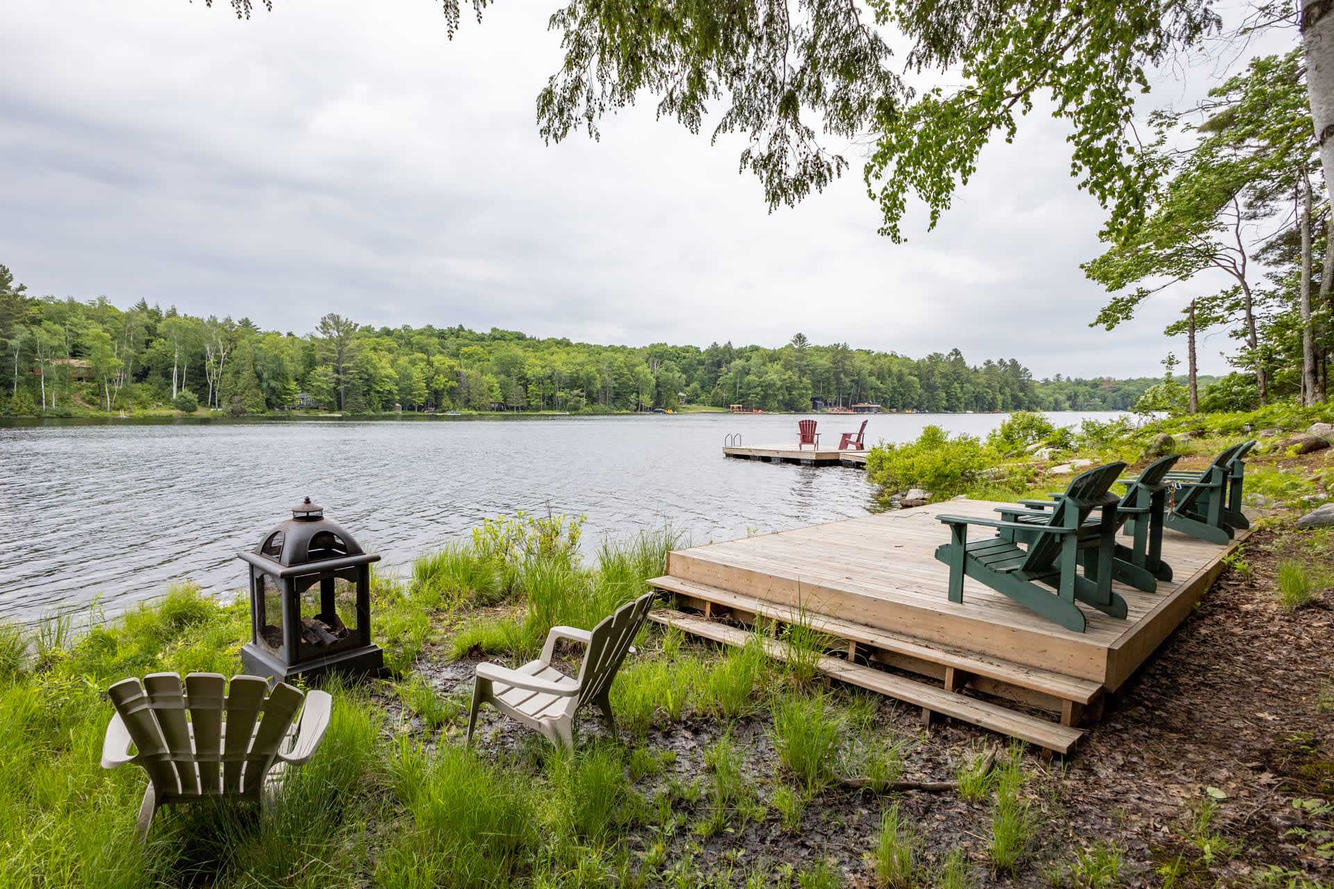 A grassy fire pit area beside the lakeside dock