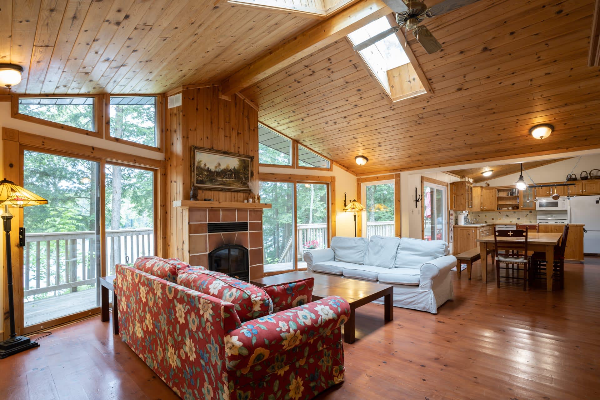 A red floral couch faces a white couch in a cottage living room