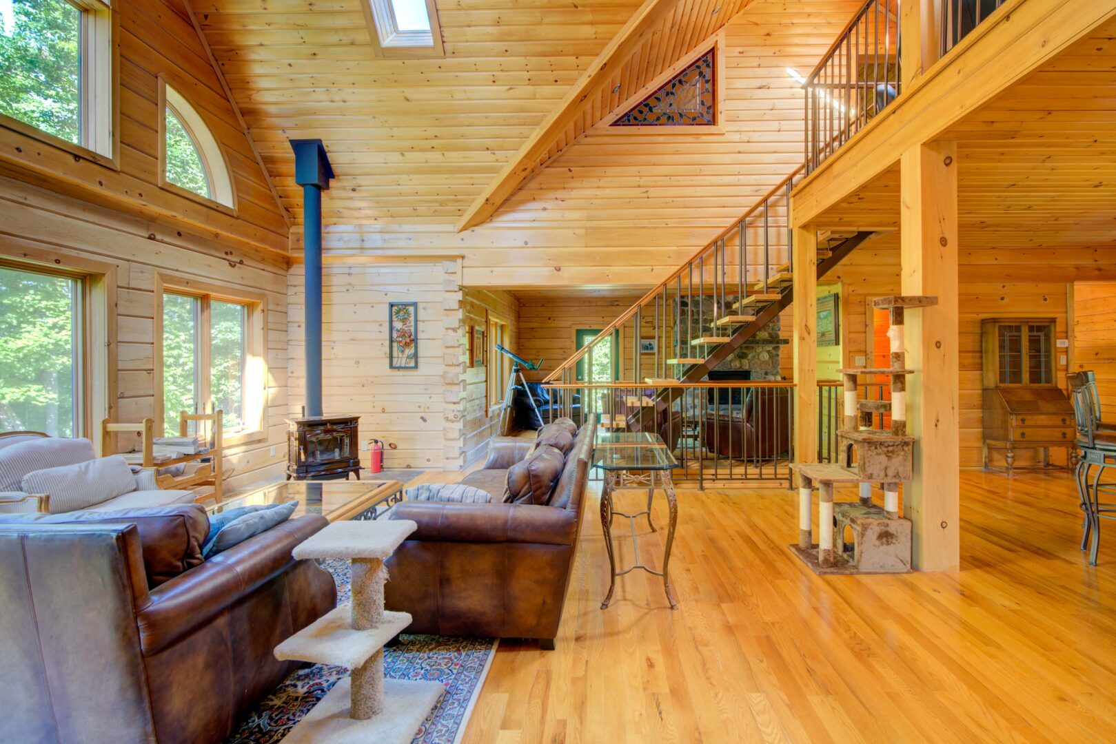 A brown leather living room set in a wood paneled living room