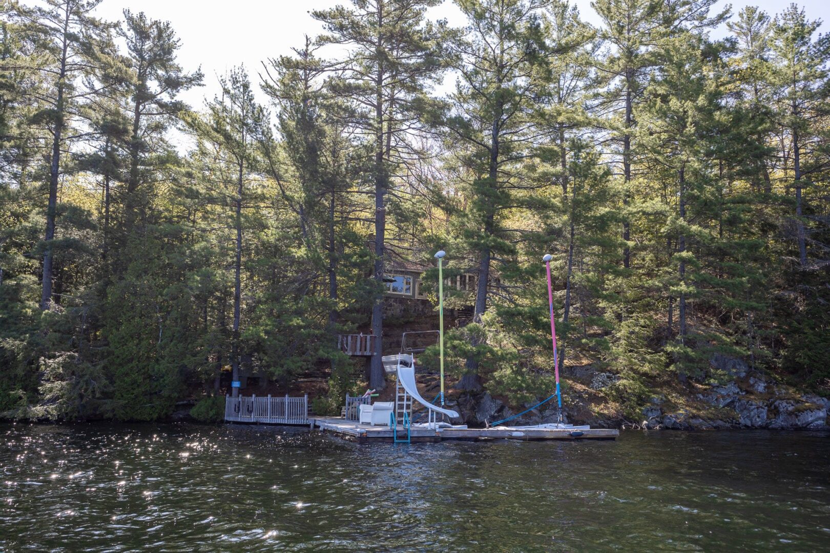 A cottage set back behind the trees on a waterfront property