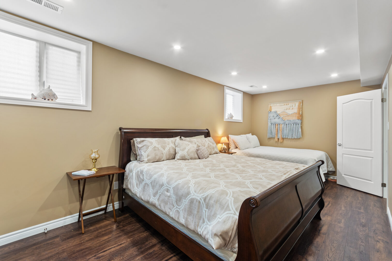 A dark brown sled bed in a beige bedroom