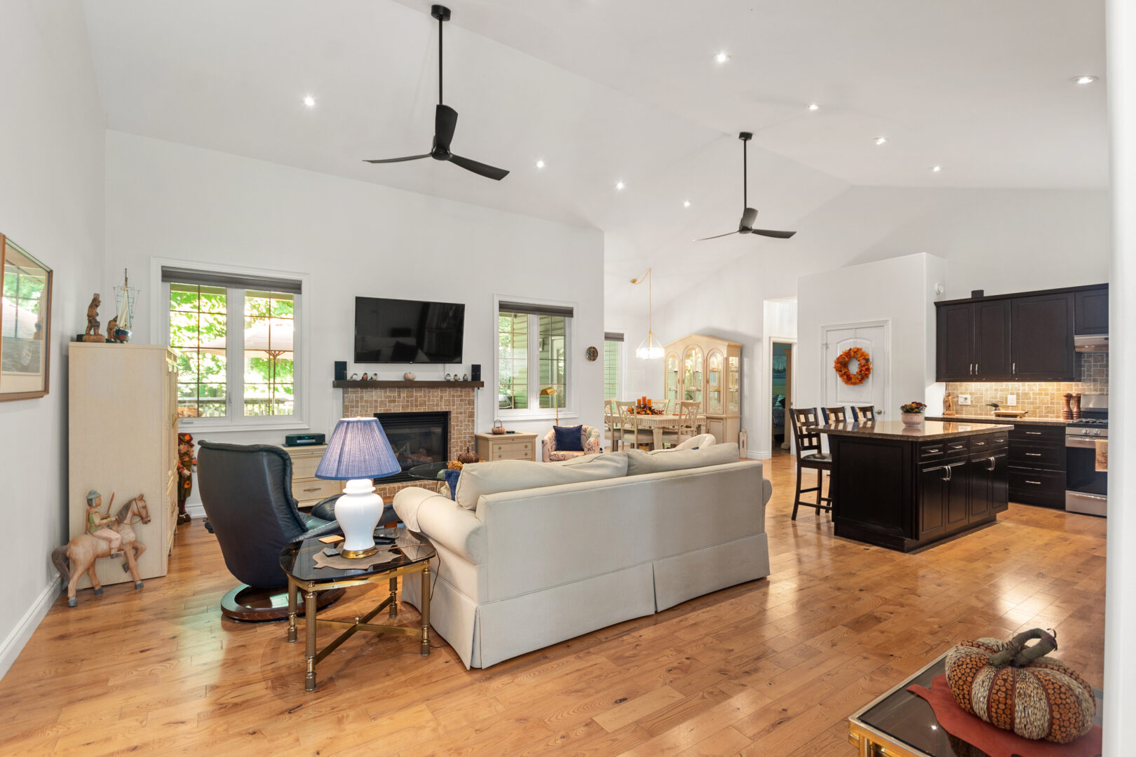 A beige couch faces a fireplace with a TV hanging above