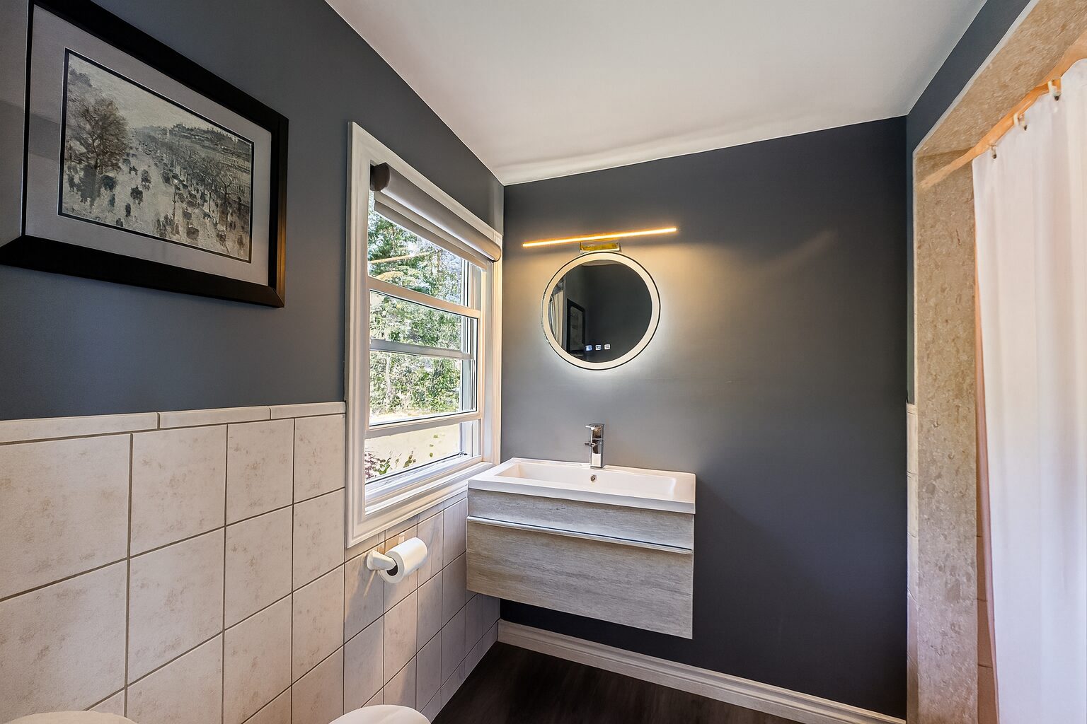 A grey bathroom with white tiles on the walls