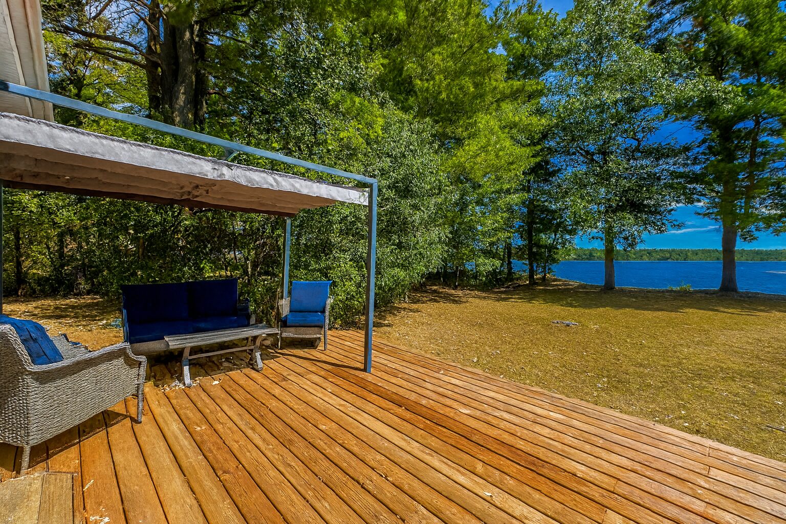A wood deck with a blue sitting area facing the lake