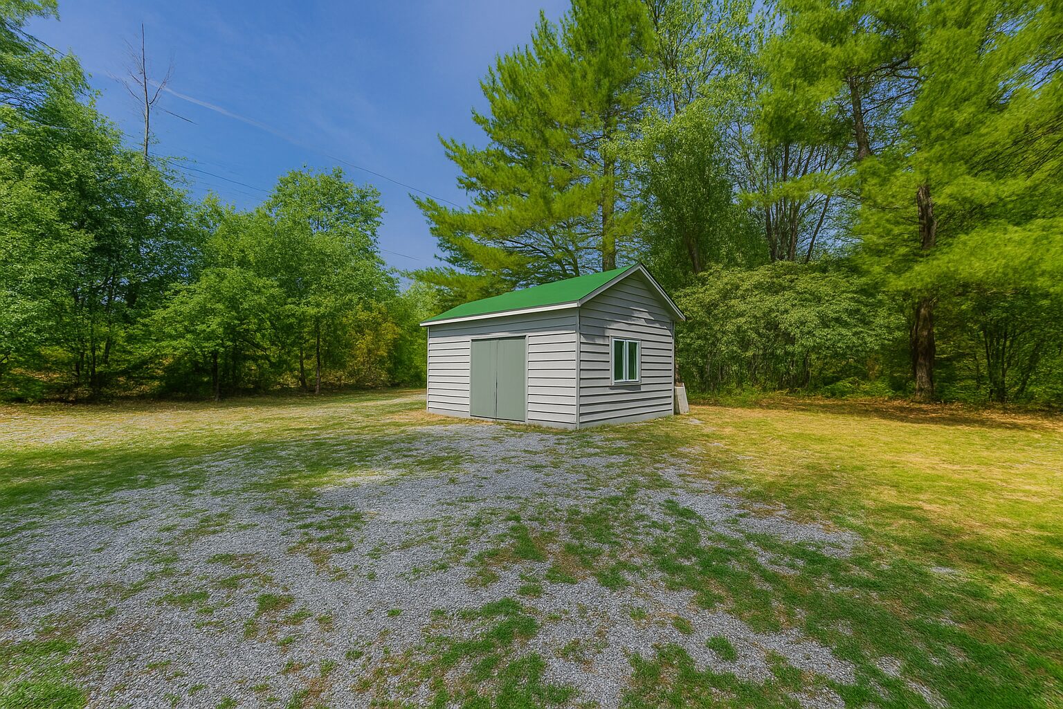 A grey shed on a sparse lawn