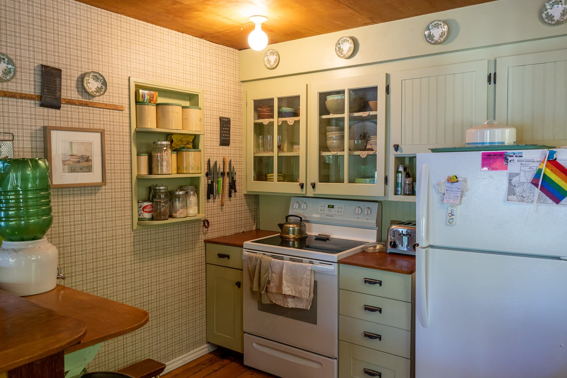A light green kitchen area with white appliances