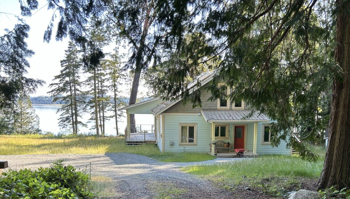 Wooded front entry of west coast-style cottage overlooking the water