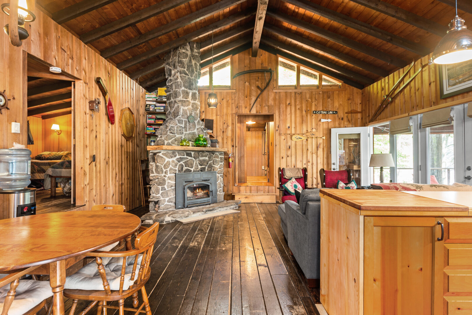 A wood cottage interior with a stone fireplace