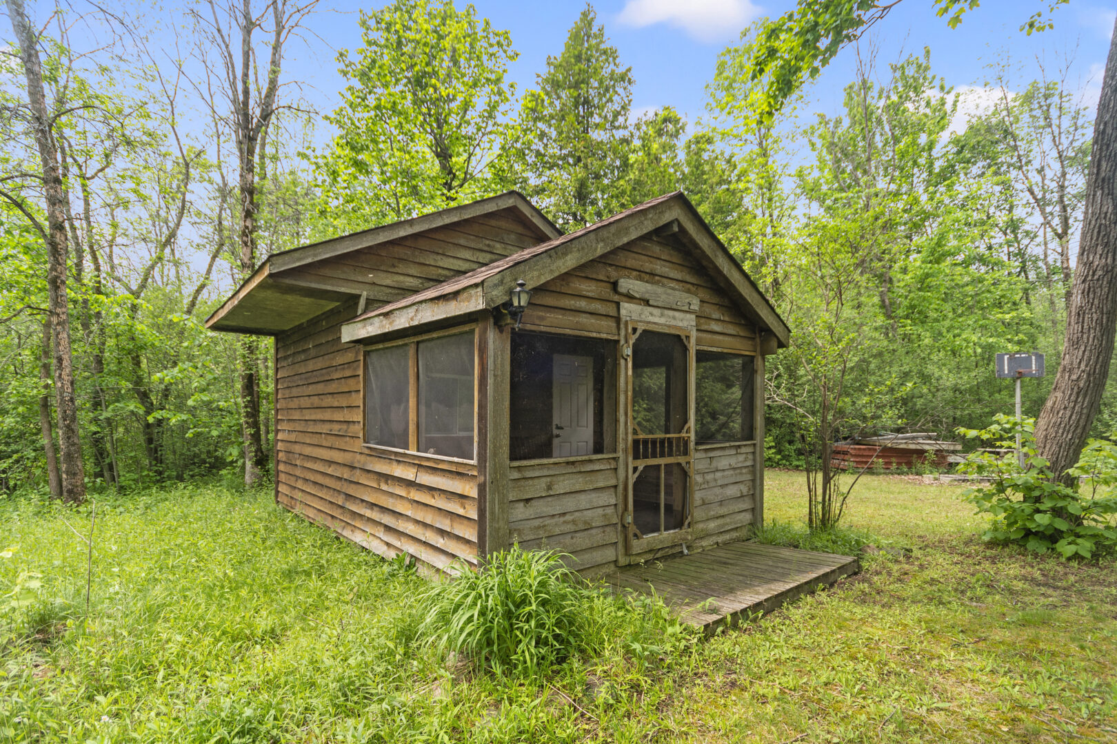 A small wood cabin in a grassy area