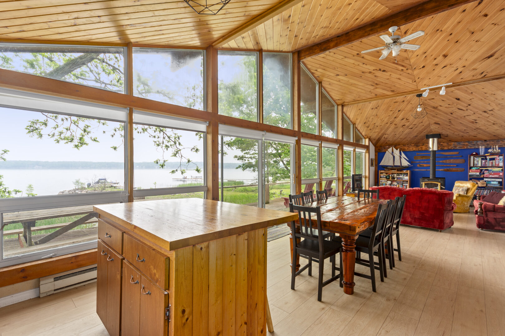 A wood island next to a rectangular dining table in a bright living room