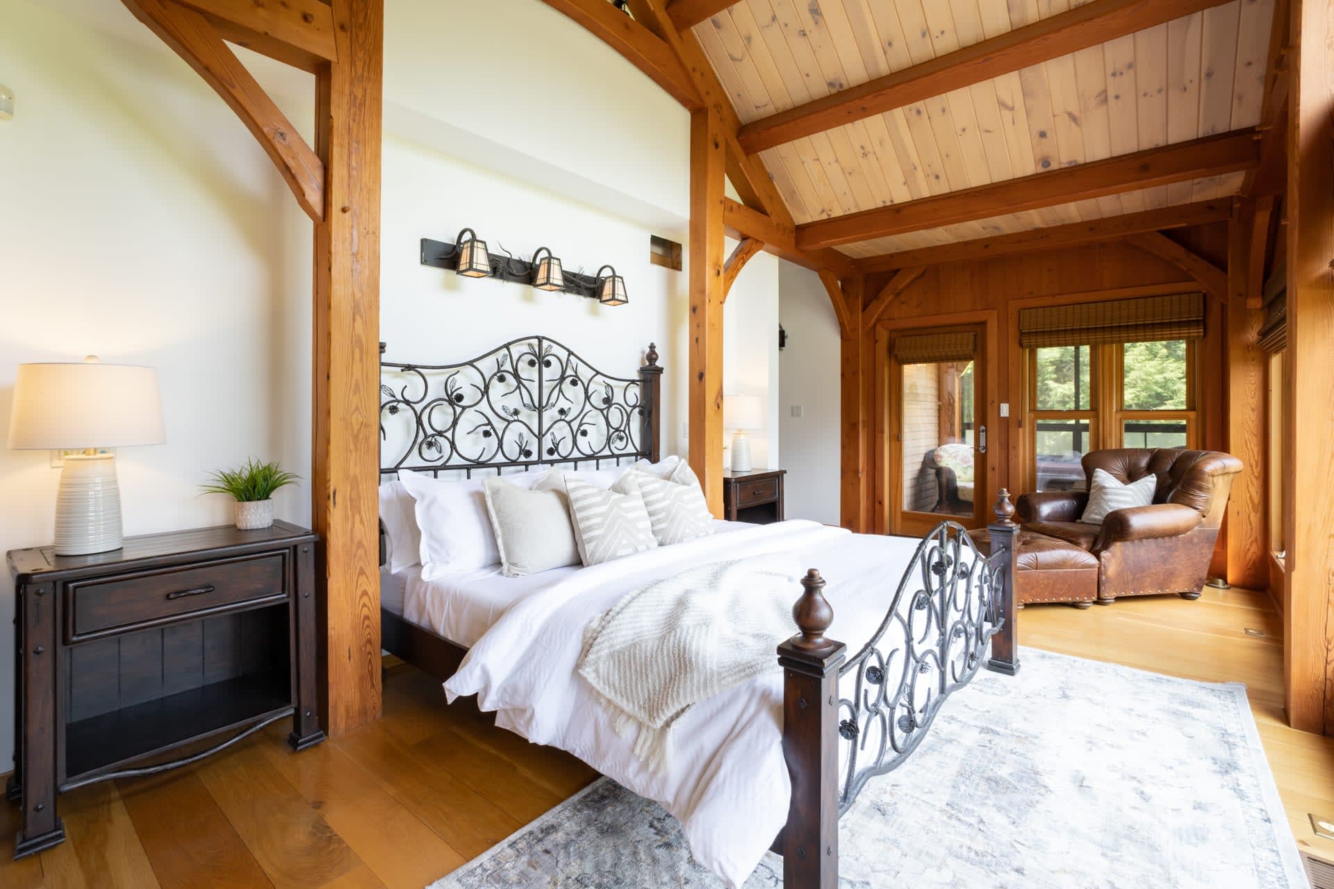 A white bedroom with a large metal bed with white bedding