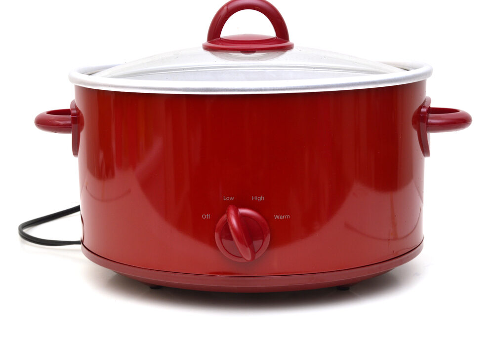 A red slow cooker against a white background