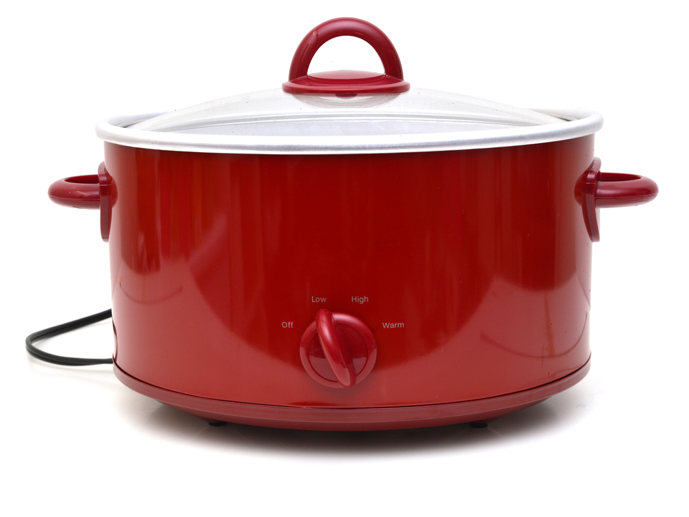 A red slow cooker against a white background