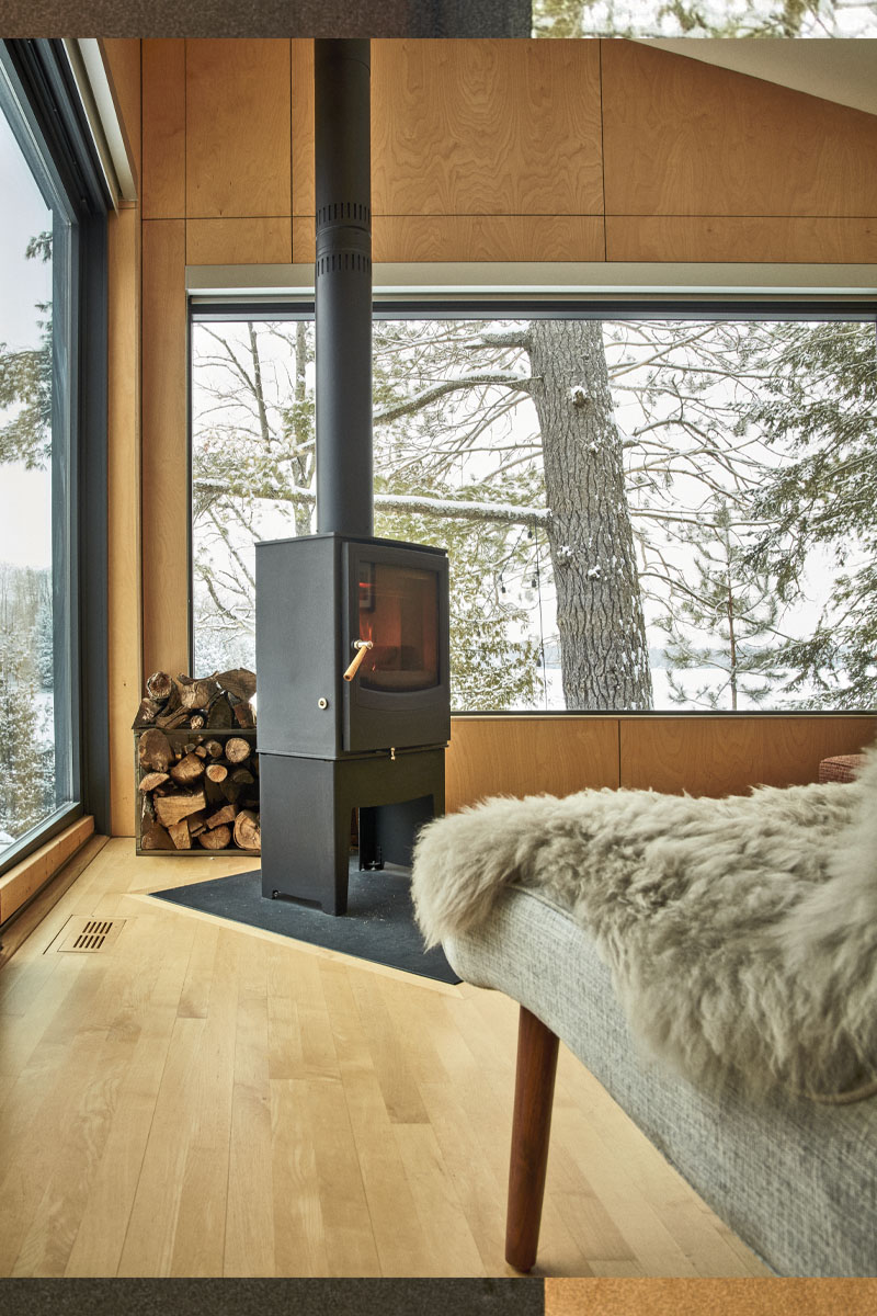 The woodstove in one of the bedrooms. The bed has a fluffy throw on it