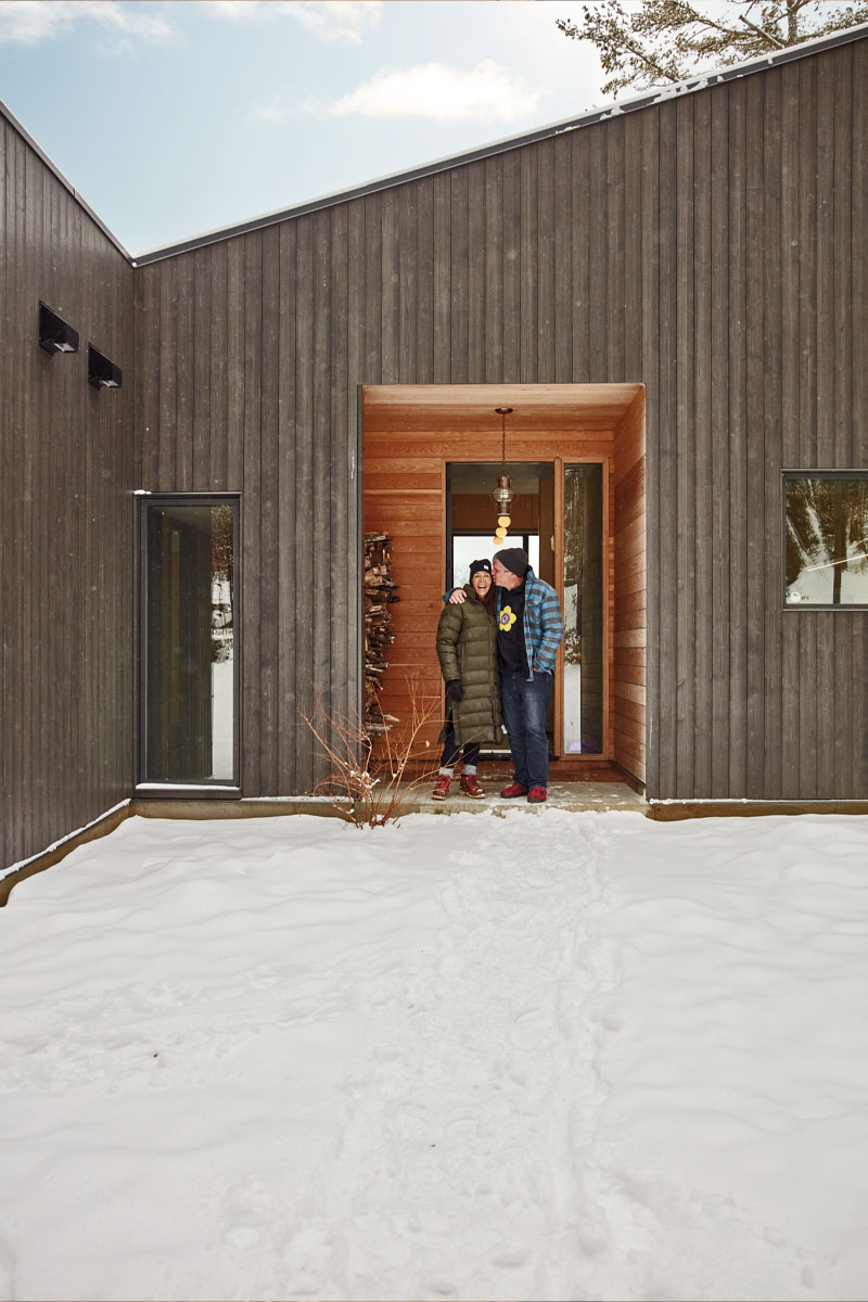 Rob and Nyla stand in the entrance of the cottage