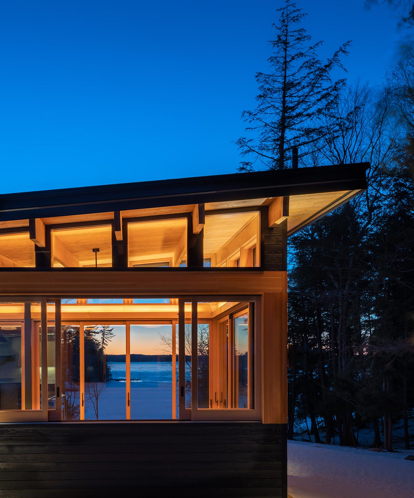 The exterior of the Heated Rivalry cottage on Lake Muskoka at night