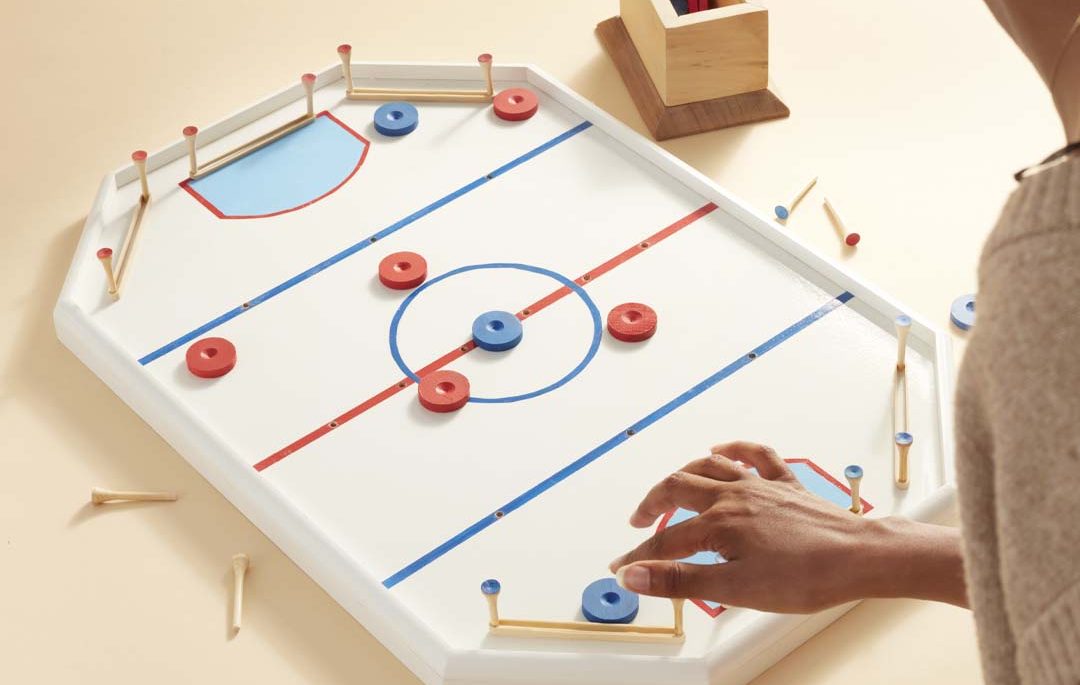 Someone playing the tabletop crockey rink game
