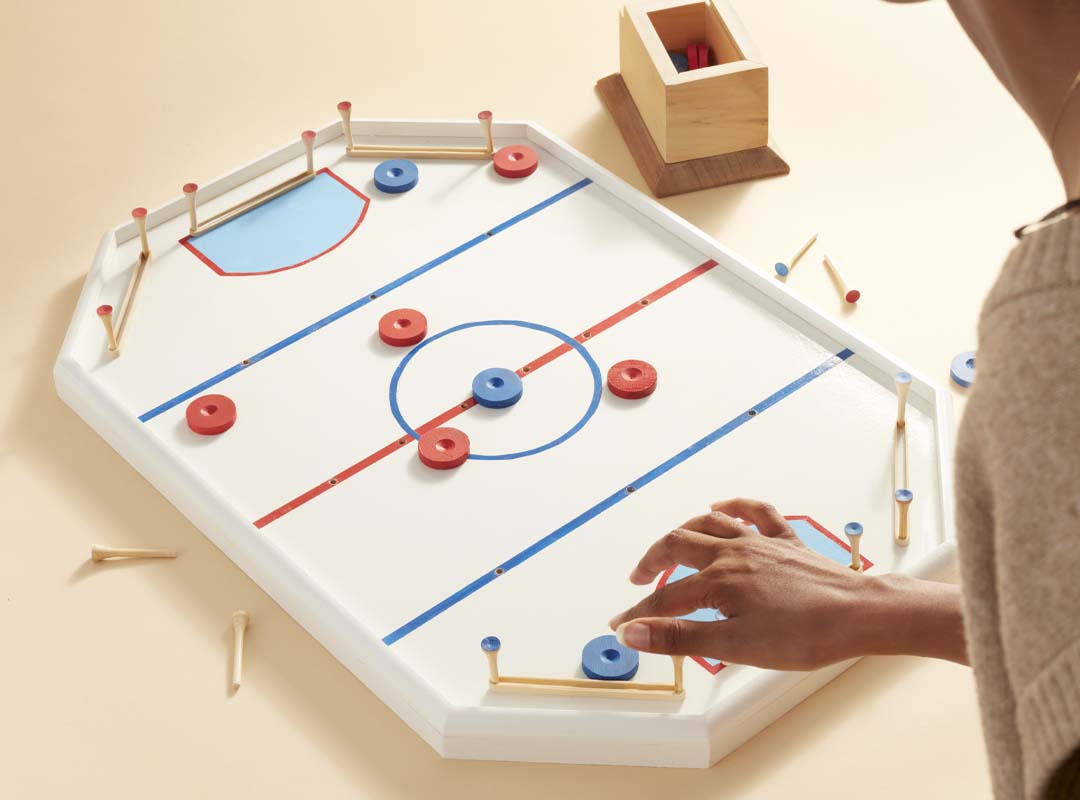 Someone playing the tabletop crockey rink game