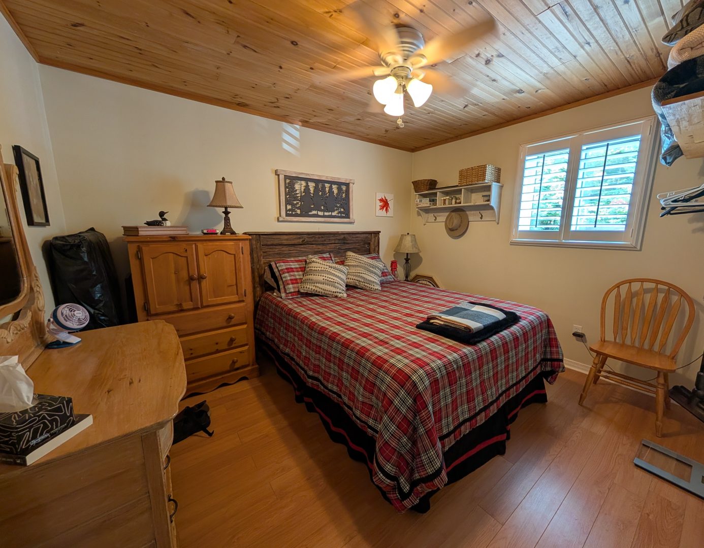 A bed with a red bedspread in a white bedroom