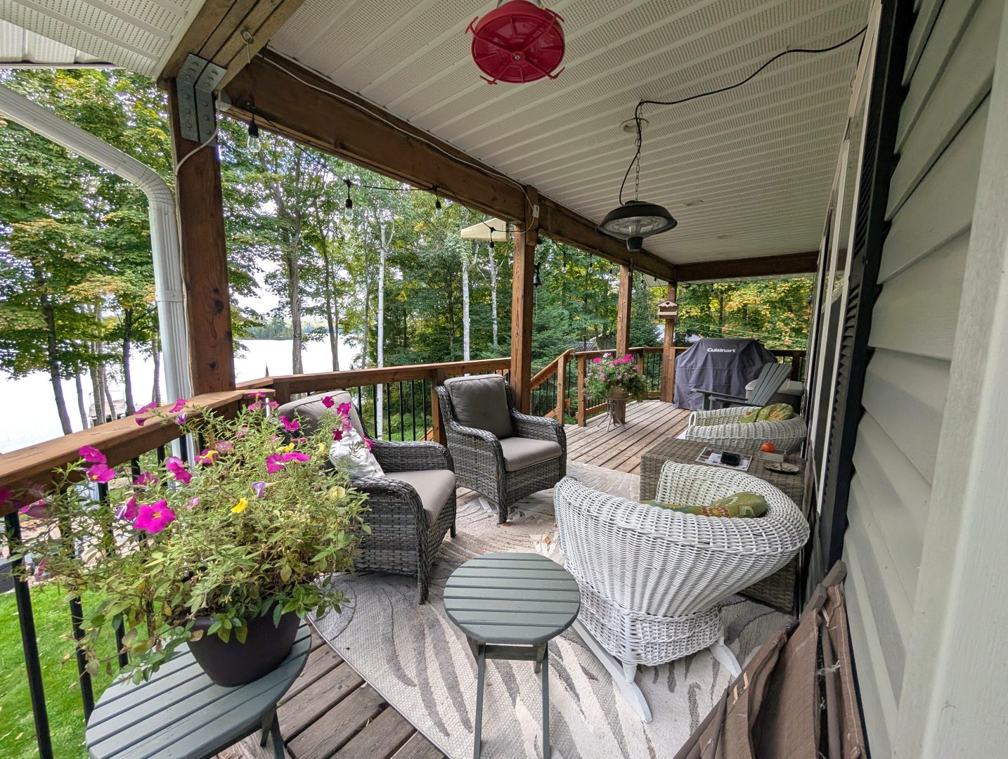 A wood deck with rattan and wicker furniture with views to the lake