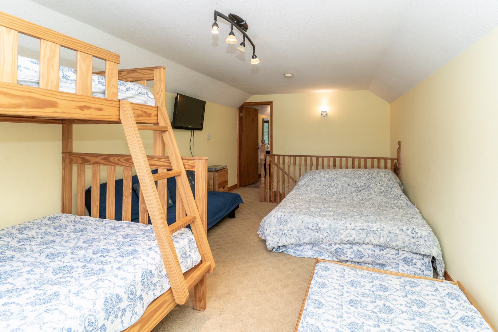 Bunk beds and mattresses with patterned covers on the floor in a white bedroom