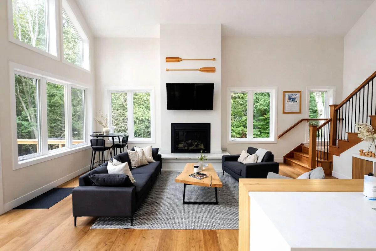 Living room of Sutton lakehouse. The living room features black couches and a wooden coffee table.