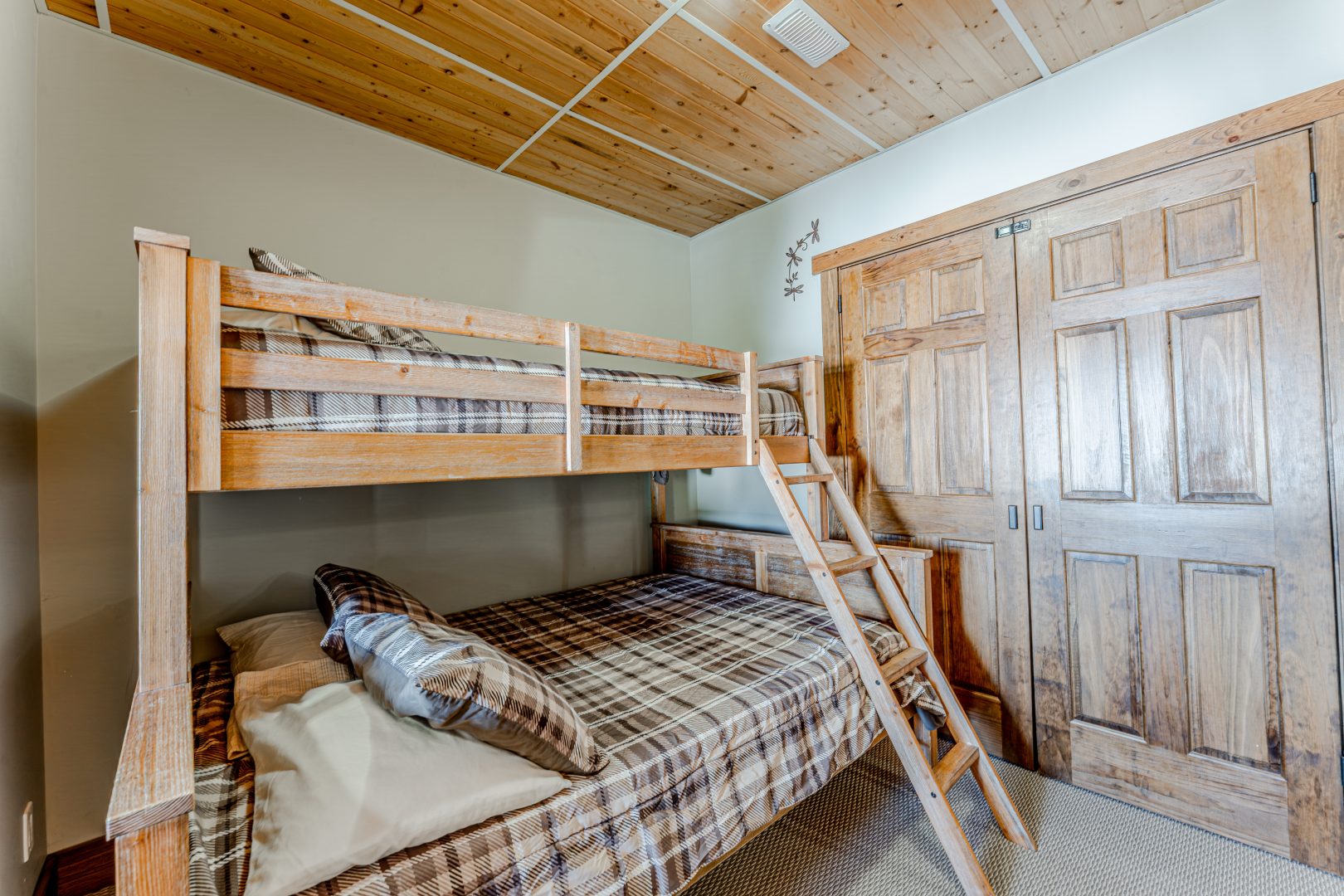 Brown and white plaid beds on a light brown bunk bed frame