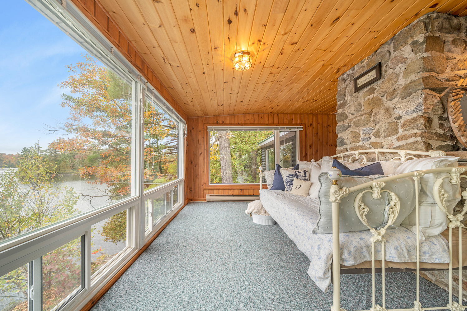A white metal couch faces out towards floor-to-ceiling windows