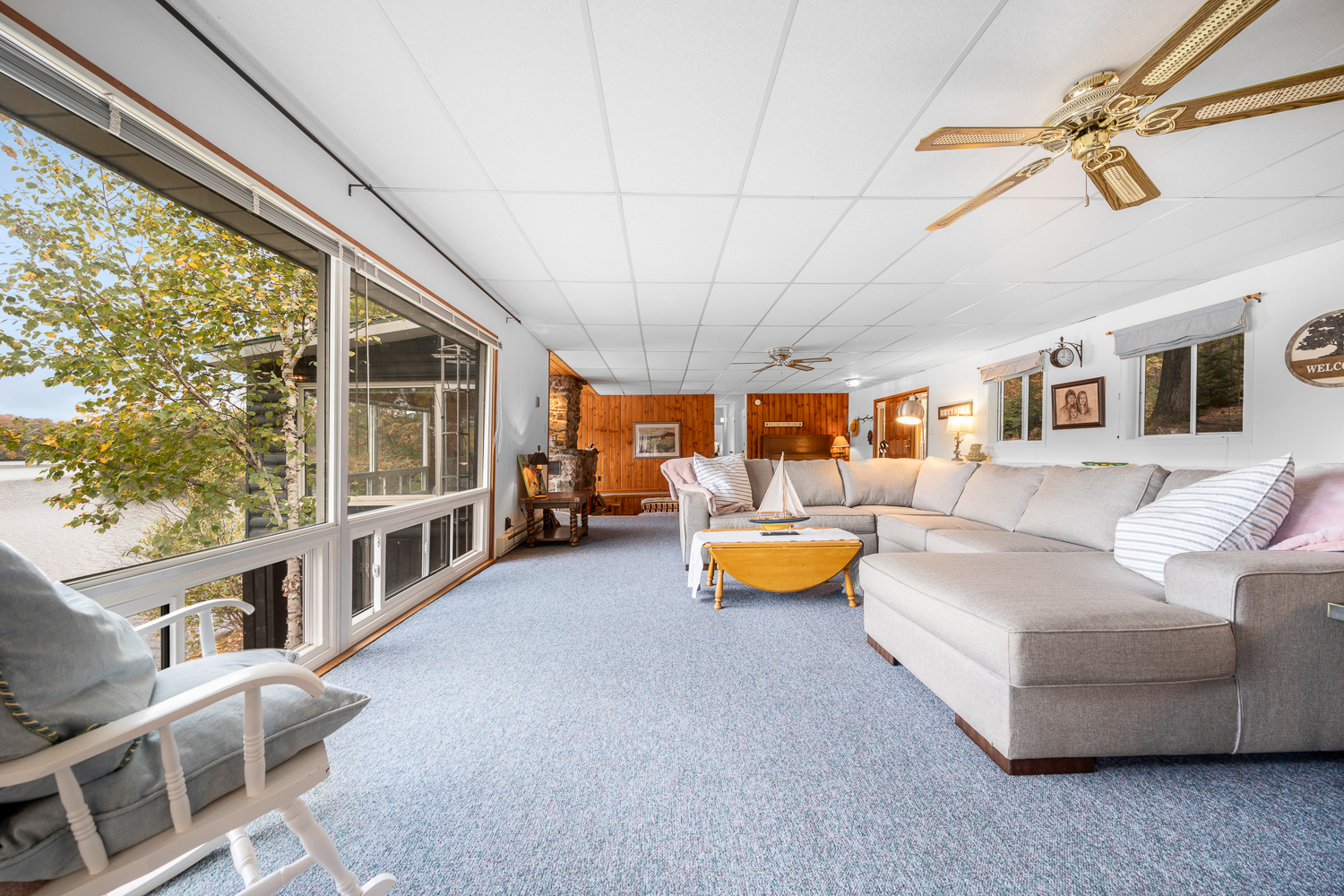 A beige couches faces floor-to-ceiling windows