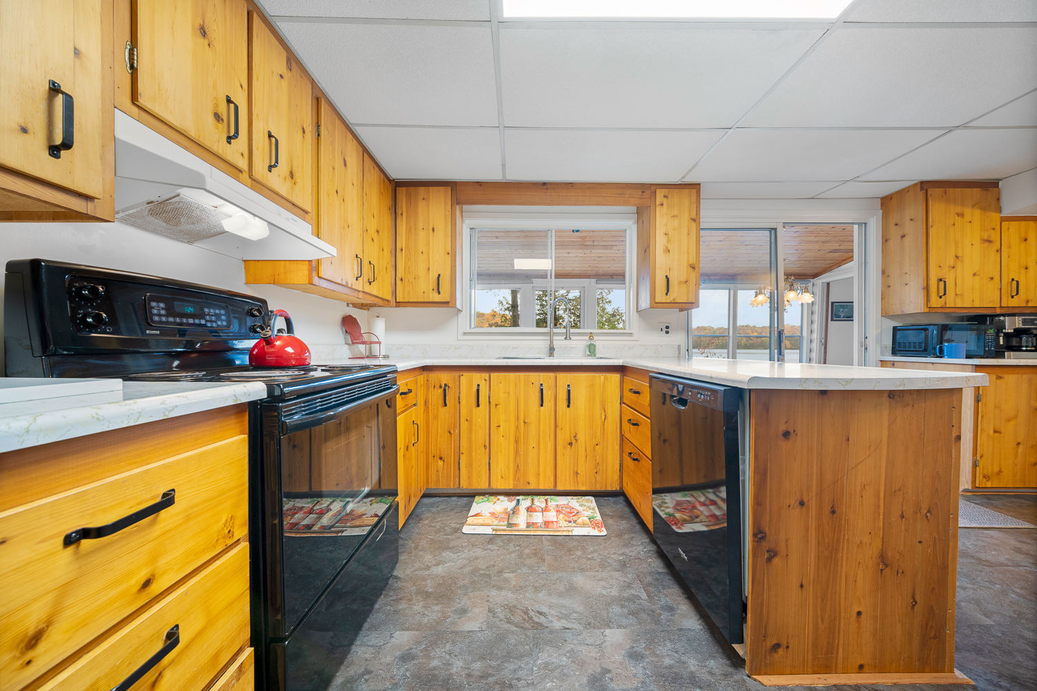A light wood kitchen with black appliances