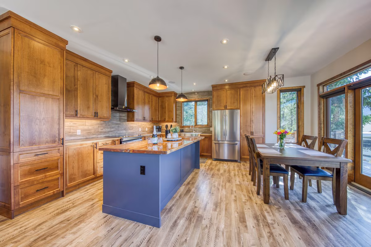 Kitchen of the serene mountain cabin. The photo showcases wooden floors and cabinets with an island in the middle