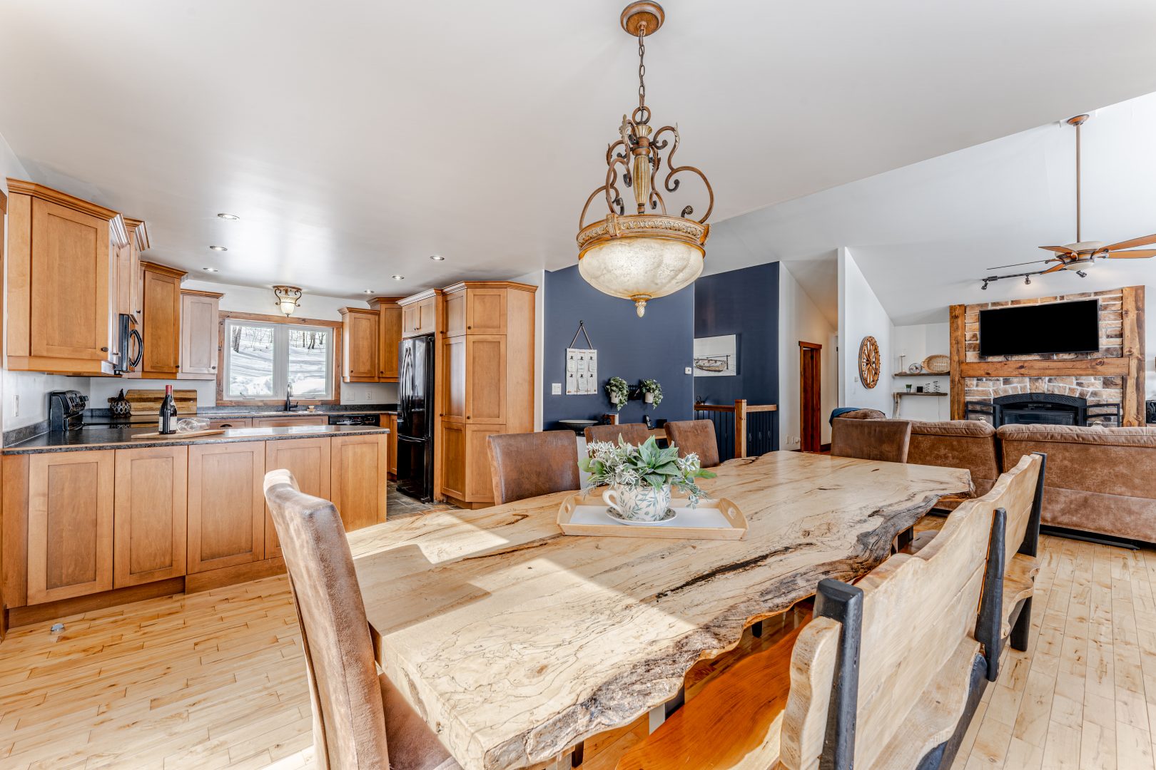 A natural-shaped wood dining table in a spacious kitchen