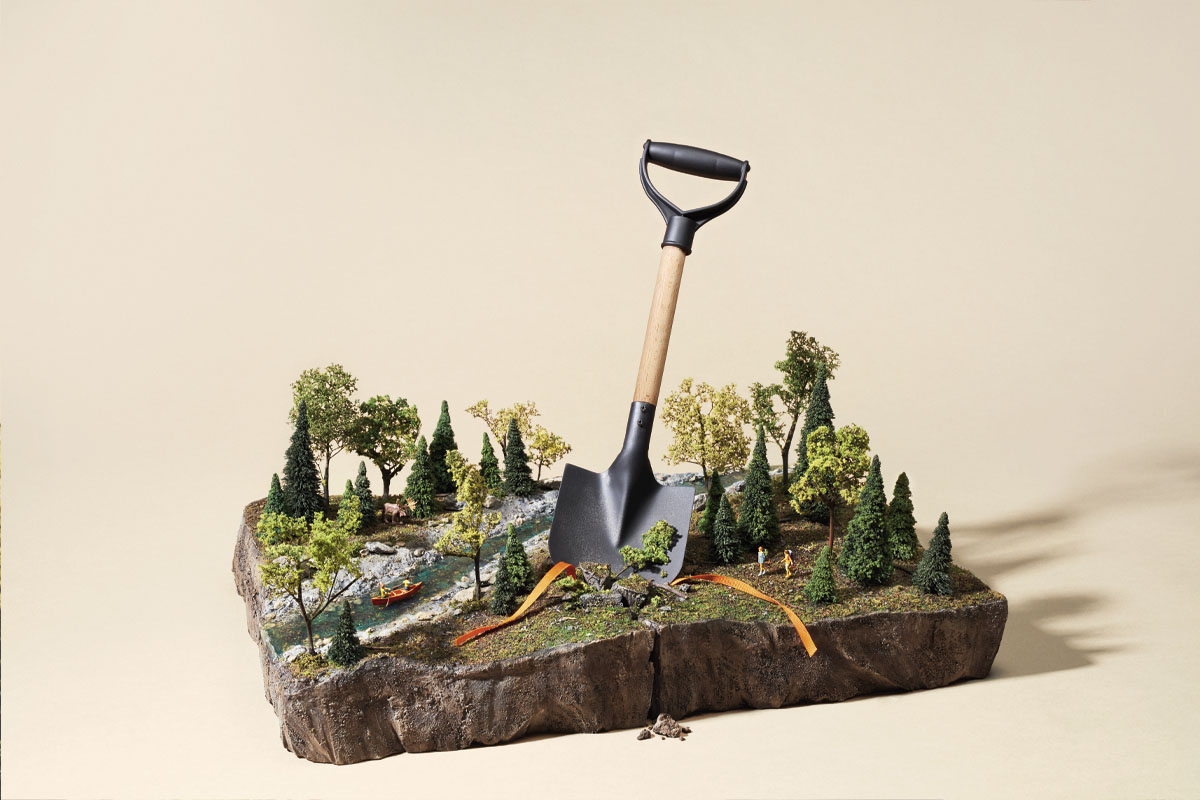 A small shovel digging into a diorama of a forest and lake. This is a depiction of what may happen to Ontario's conservation authorities.