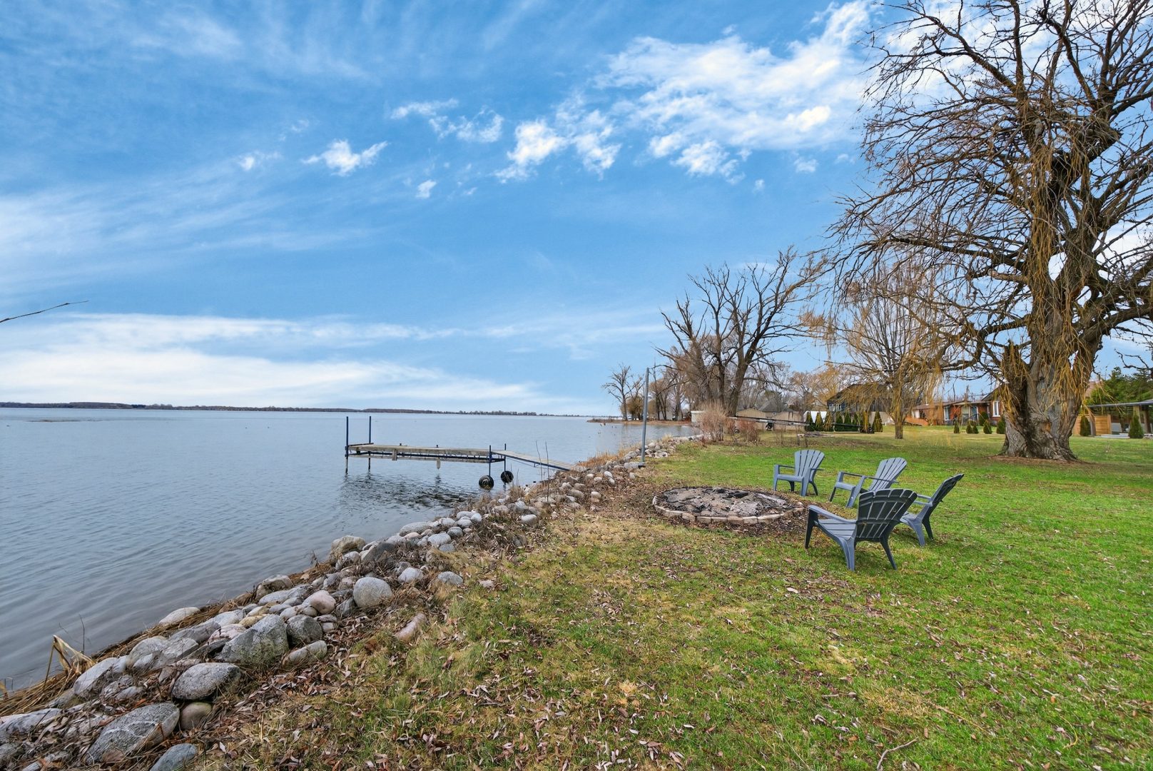 A dock in the water next to a grassy shore