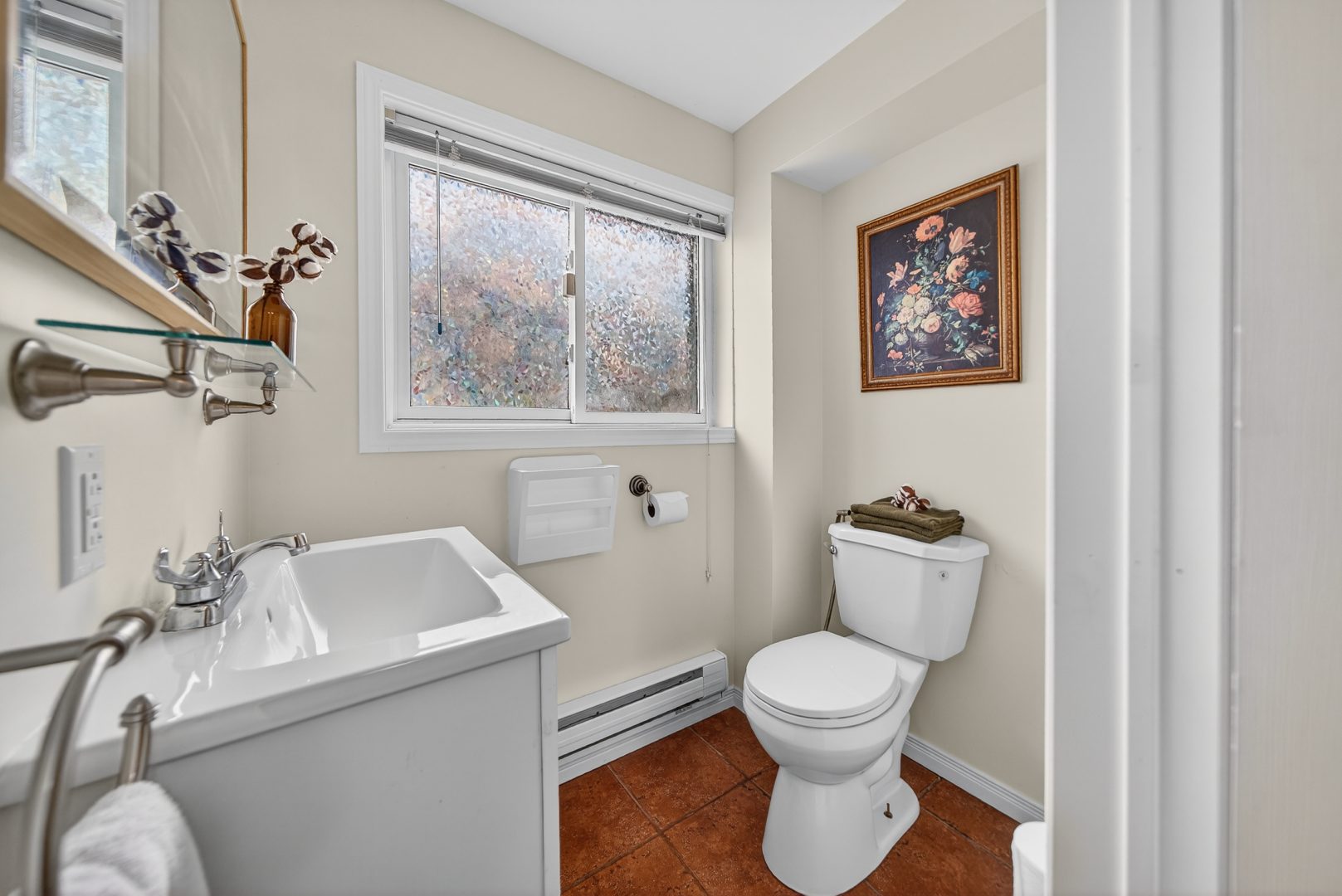 A white bathroom with terracotta floors
